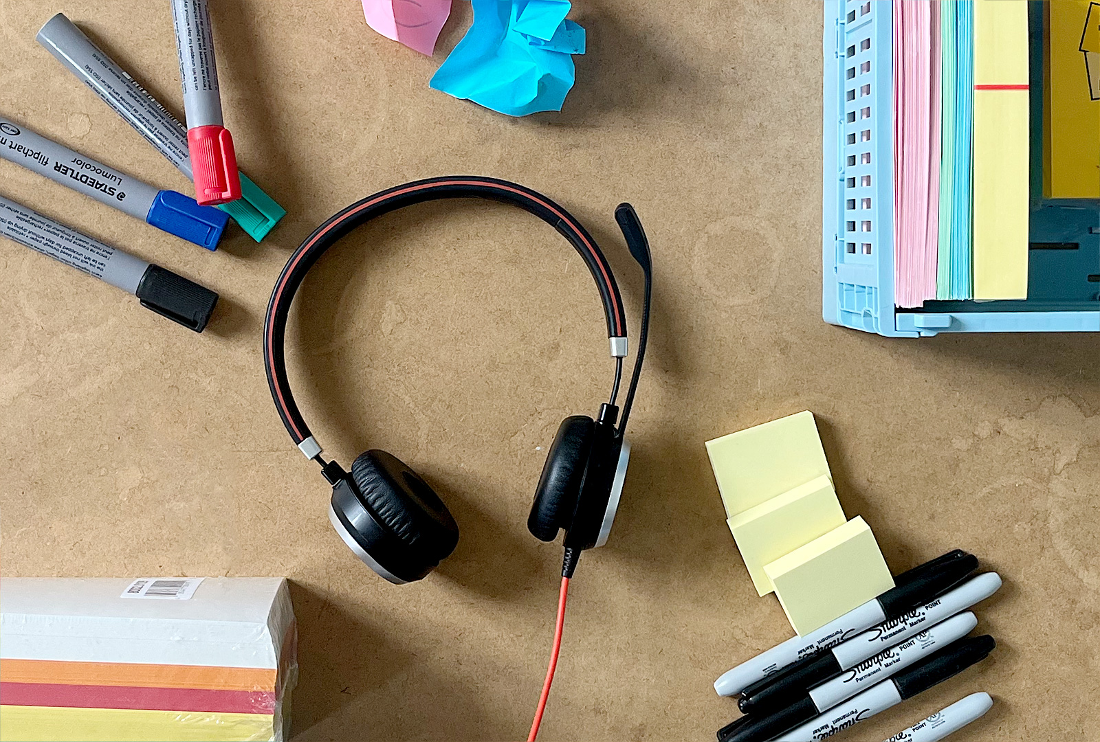 Pens, sticky notes and a headset on Nina's desk